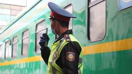 Транспортный полицейский говорит по рации возле поезда