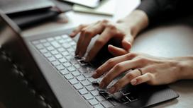 Женщина нажимает пальцами на кнопки клавиатуры ноутбука