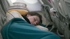 Девушка спит в самолете