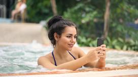 Девушка в бассейне со смартфоном