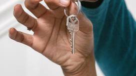 Женщина держит в руках ключ от квартиры