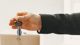 Мужчина держит ключи от квартиры в руке