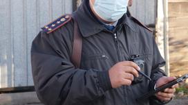 Полицейский в маске стоит на улице