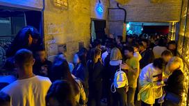Толпа людей стоит в коридоре ночного клуба