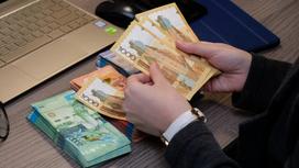 Ақша санап отырған адам