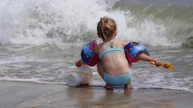 Девочка с ведерком на пляже