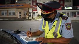 полицейский заполняет документы на капоте авто