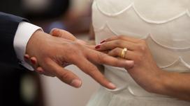 Невеста надевает кольцо на палец жениха