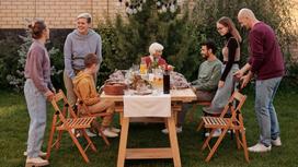 Семья из нескольких человек за столиком в саду