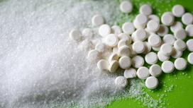 Сахар и таблетки сахарозаменителя рассыпаны на столе