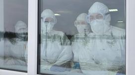 Работники инфекционного отделения смотрят в окно