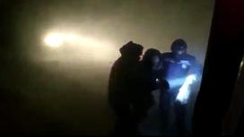 Спасатели ведут человека к машине во время бурана