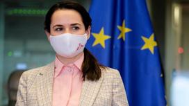 Светлана Тихановская в маске на фоне флага Евросоюза