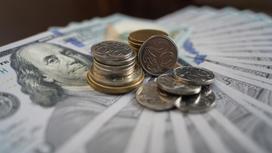 Доллары и монеты тенге лежат на столе