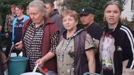 Жители села стоят с ведрами в очереди за водой