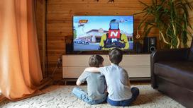 Дети смотрят мультик на телевизоре
