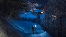 Человек идет с фонарем ночью зимой