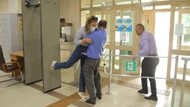 Охранник тащит журналистку к выходу из здания акимата в Алматы
