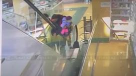Женщина с ребенком поднимается на эскалаторе