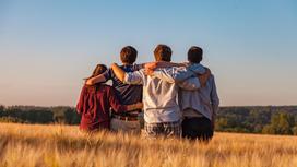 Четверо подростков в поле обнимаются