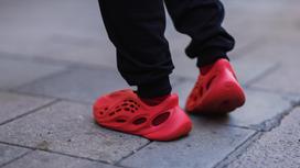 Мужчина в красных кроссовках Yeezy