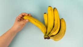 Рука возле бананов