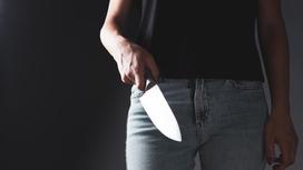 Девушка держит нож в руке