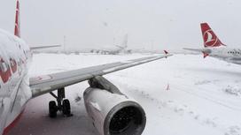 Снег падает на крыло самолета
