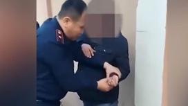 Полицейский держит руку мужчины