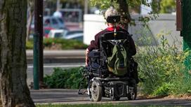 Женщина едет на инвалидной коляске