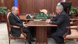Владимир Путин и Сергей Шойгу сидят за столом