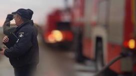 Полицейский стоит рядом с пожарной машиной