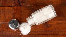 Опрокинутая солонка и рассыпанная соль на столе