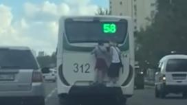 Подростки катаются на заднем бампере автобуса