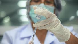 Медработница держит в руке ампулу с вакциной