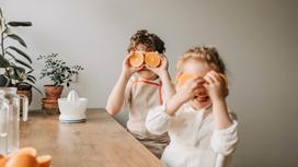Дети за столом с апельсинами