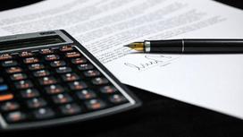 Калькулятор и подписанный документ лежат на столе
