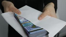 Женщина держит в руках конверт с деньгами