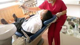 Врач-стоматолог лечит зубы пациенту