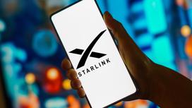 Человек держит смартфон с логотипом Starlink