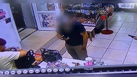 Мужчина с телефоном возле кассы в магазине