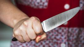 Женщина держит в руке нож