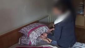 Женщина показывает, как задушила сына в Алматинской области