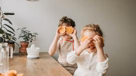 Дети держат апельсины
