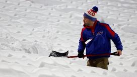 Мужчина убирает снег лопатой
