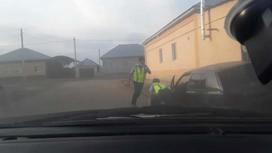 Двое полицейских задерживают водителя автомашины