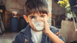 Мальчик пьет молоко из стакана