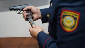 Полицейский держит в руке пистолет