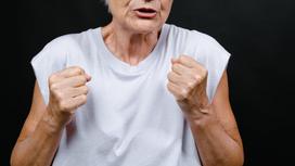 Сердитая женщина показывает кулаки