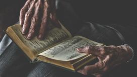 Пожилой человек читает книгу